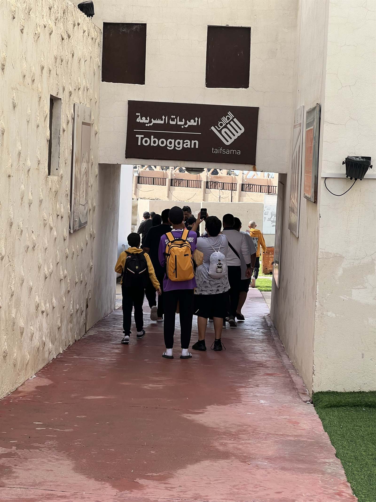 Students walking a corridor toward the rides area in Taif